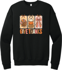 Give Thanks Coquette crewneck sweatshirt in Black, featuring three bow-topped stamp panels with a turkey, stacked pumpkins, and a pink bow above Give Thanks in patchwork letters