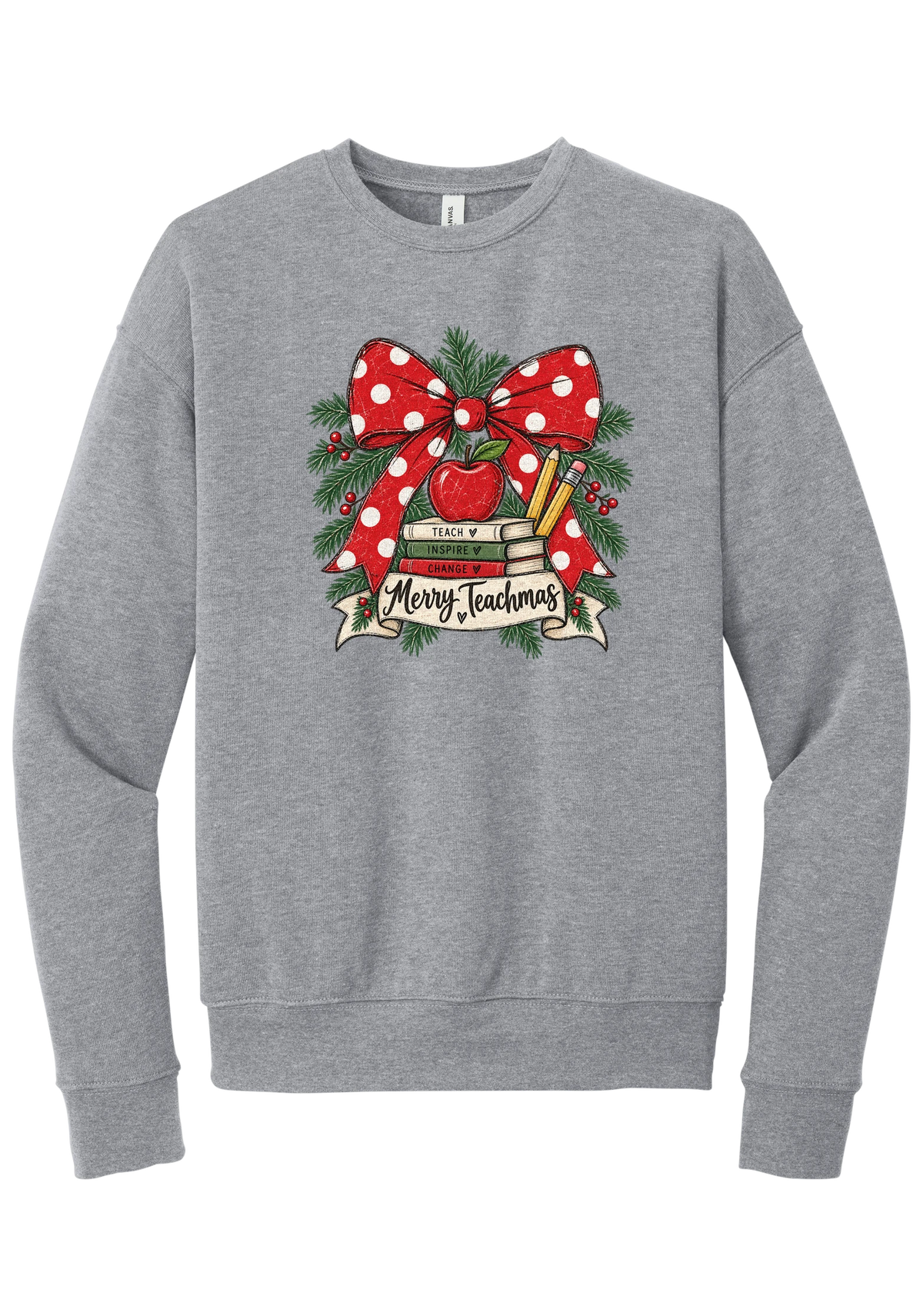 Merry Teachmas crewneck sweatshirt in Athletic Heather, featuring a red polka dot bow over a stack of books reading Teach, Inspire, Change with an apple, pencils, evergreen, and a Merry Teachmas banner
