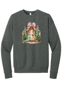 Painterly Nativity crewneck sweatshirt in Deep Heather, featuring a painterly nativity scene with Mary, Joseph, and baby Jesus in a wooden stable between teal Christmas trees and a pink bow