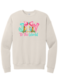 Joy to the World Nativity crewneck sweatshirt in Heather Dust, featuring painted JOY letters framing a nativity scene with a pink bow and To The World script