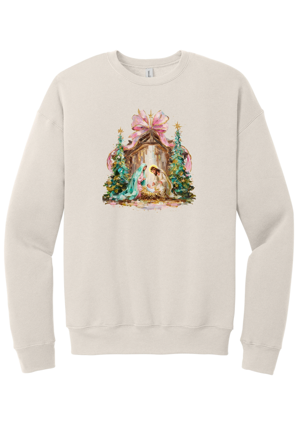 Painterly Nativity crewneck sweatshirt in Heather Dust, featuring a painterly nativity scene with Mary, Joseph, and baby Jesus in a wooden stable between teal Christmas trees and a pink bow