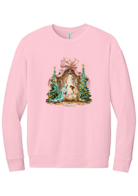 Painterly Nativity crewneck sweatshirt in Pink, featuring a painterly nativity scene with Mary, Joseph, and baby Jesus in a wooden stable between teal Christmas trees and a pink bow