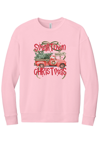 Personalized Small Town Christmas crewneck sweatshirt in Pink, featuring Santa in a vintage red pickup truck hauling a Christmas tree past a personalized town road sign, with red Small Town Christmas lettering