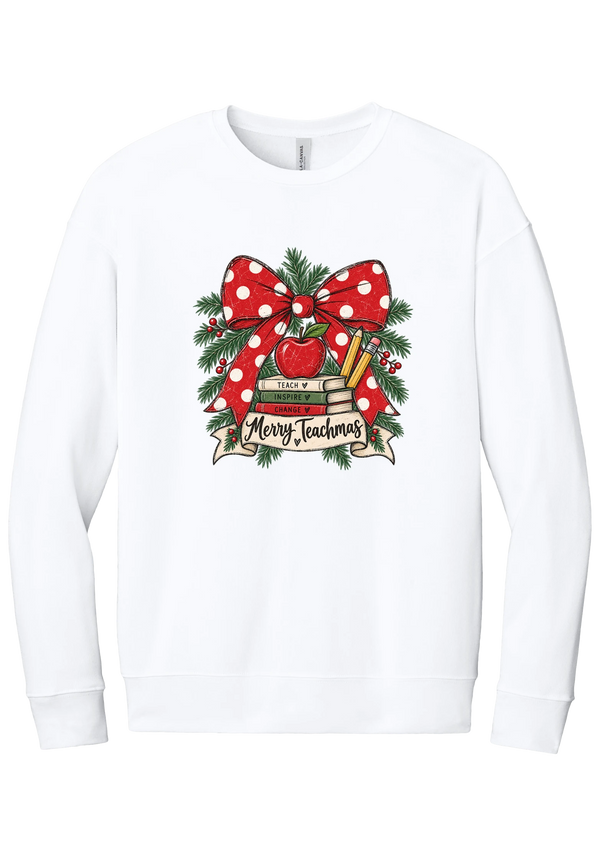 Merry Teachmas crewneck sweatshirt in White, featuring a red polka dot bow over a stack of books reading Teach, Inspire, Change with an apple, pencils, evergreen, and a Merry Teachmas banner