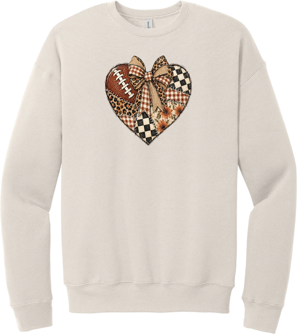 For the Love of Football crewneck sweatshirt in Heather Dust, featuring a patchwork heart in leopard, plaid, and checkerboard with a football and a cream bow