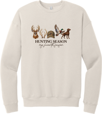 Hunting Season crewneck sweatshirt in Heather Dust, featuring a whitetail buck, antlers, a camo cap, a flying mallard, and a chocolate lab above Hunting Season My Favorite Season lettering