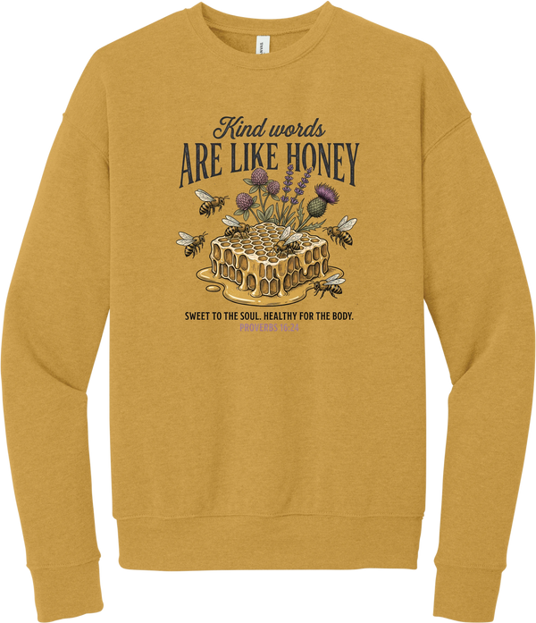 Words Like Honey crewneck sweatshirt in Heather Mustard, featuring a dripping honeycomb with bees and wildflowers under Kind Words Are Like Honey lettering and Proverbs 16:24