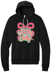 Holly Jolly Bow Script hoodie in Black, featuring pink gingham Holly Jolly script on a teal badge framed by a big pink bow