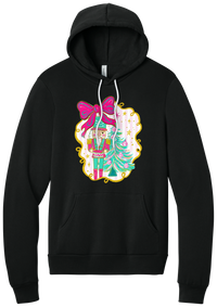 Nutcracker Bow hoodie in Black, featuring a teal and pink nutcracker beside a tinsel tree under a big hot pink bow