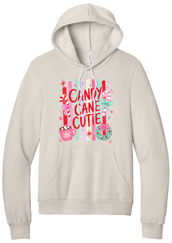 Candy Cane Cutie hoodie in Heather Dust, featuring red CANDY CANE CUTIE letters on pastel stripes with candy canes, cocoa, and bows