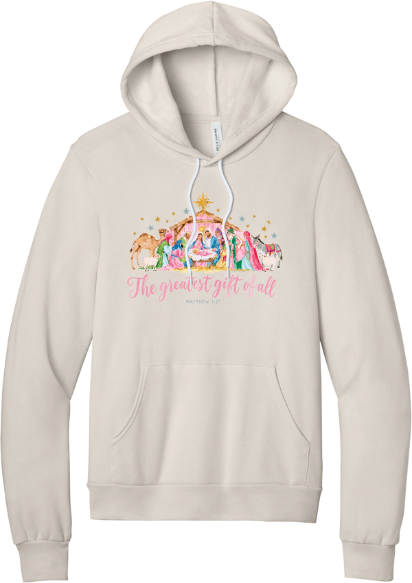 The Greatest Gift of All hoodie in Heather Dust, featuring a pastel watercolor nativity scene under the star with The Greatest Gift of All script and Matthew 1:21