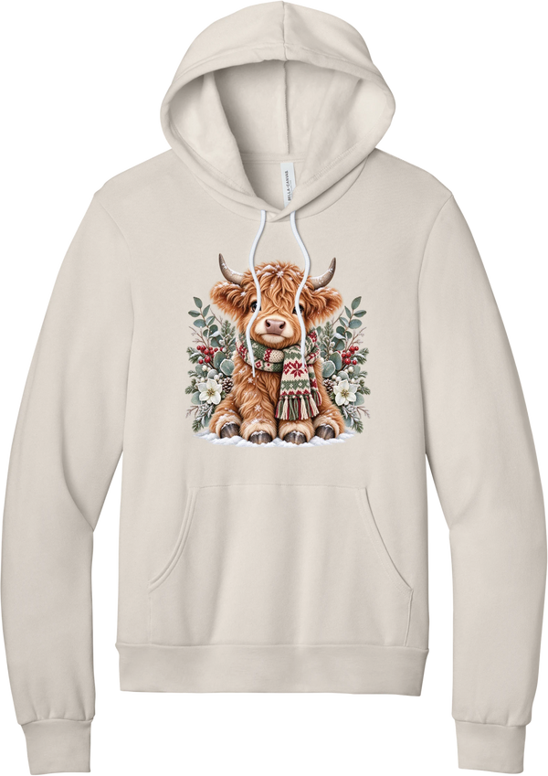 Highland Holidays hoodie in Heather Dust, featuring a fluffy baby Highland cow in a Fair Isle knit scarf, surrounded by frosted eucalyptus, pine, red berries, and white Christmas roses