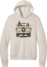Christmas Pickup Truck with Dog hoodie in Heather Dust, featuring a vintage pickup truck with a Christmas tree, wrapped gifts, a tailgate wreath, and a dog in a Santa hat