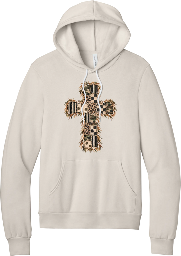 Quilted Patchwork Cross hoodie in Heather Dust, featuring a patchwork cross in camo, leopard, checkerboard, polka dot, and stripes with a fringed edge