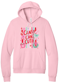 Candy Cane Cutie hoodie in Pink, featuring red CANDY CANE CUTIE letters on pastel stripes with candy canes, cocoa, and bows