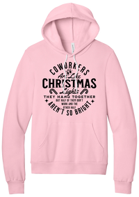 Coworkers Are Like Christmas Lights hoodie in Pink, featuring bold black type reading Coworkers Are Like Christmas Lights, they hang together but half of them don't work and the other half aren't so bright