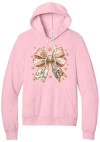 Nativity Bow hoodie in Pink, featuring a blush satin bow with painted nativity scenes in its ribbons and gold snowflakes
