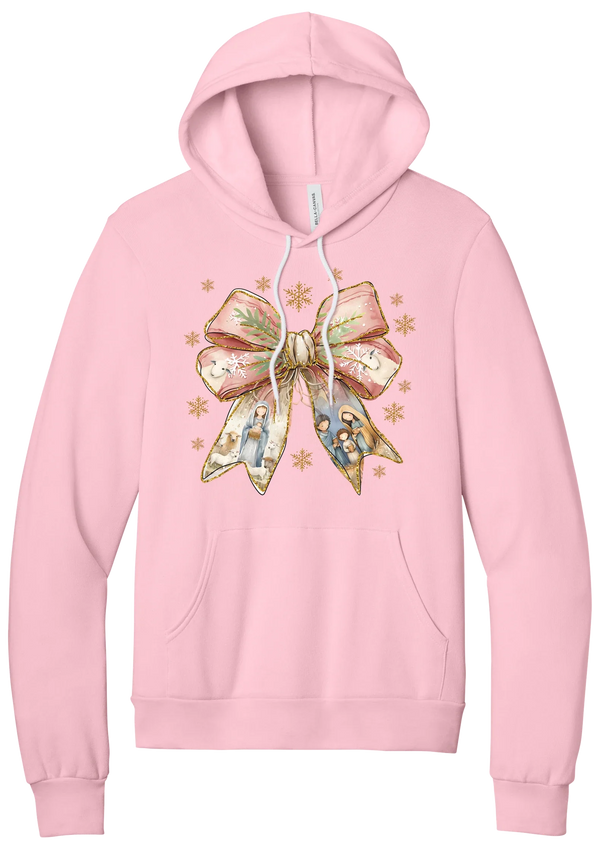 Nativity Bow hoodie in Pink, featuring a blush satin bow with painted nativity scenes in its ribbons and gold snowflakes
