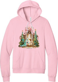 Painterly Nativity hoodie in Pink, featuring a painterly nativity scene with Mary, Joseph, and baby Jesus in a wooden stable between teal Christmas trees and a pink bow