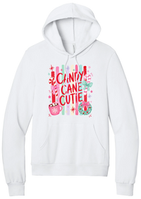 Candy Cane Cutie hoodie in White, featuring red CANDY CANE CUTIE letters on pastel stripes with candy canes, cocoa, and bows