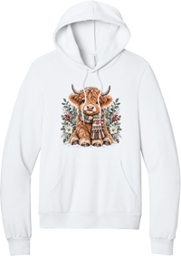 Highland Holidays hoodie in White, featuring a fluffy baby Highland cow in a Fair Isle knit scarf, surrounded by frosted eucalyptus, pine, red berries, and white Christmas roses