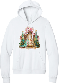 Painterly Nativity hoodie in White, featuring a painterly nativity scene with Mary, Joseph, and baby Jesus in a wooden stable between teal Christmas trees and a pink bow