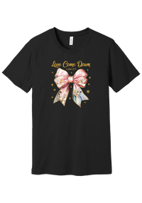 Love Came Down Nativity Bow tee in Black, featuring a blush satin bow with painted nativity scenes under gold Love Came Down script and Luke 2:11