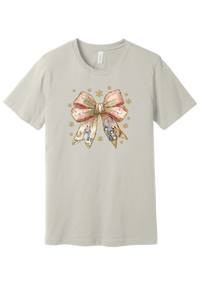 Nativity Bow tee in Dust, featuring a blush satin bow with painted nativity scenes in its ribbons and gold snowflakes