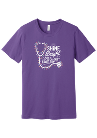 Shine Bright Like a Call Light tee in Royal Purple, featuring a white stethoscope wrapped in multicolor Christmas lights with bold Shine Bright Like a Call Light lettering