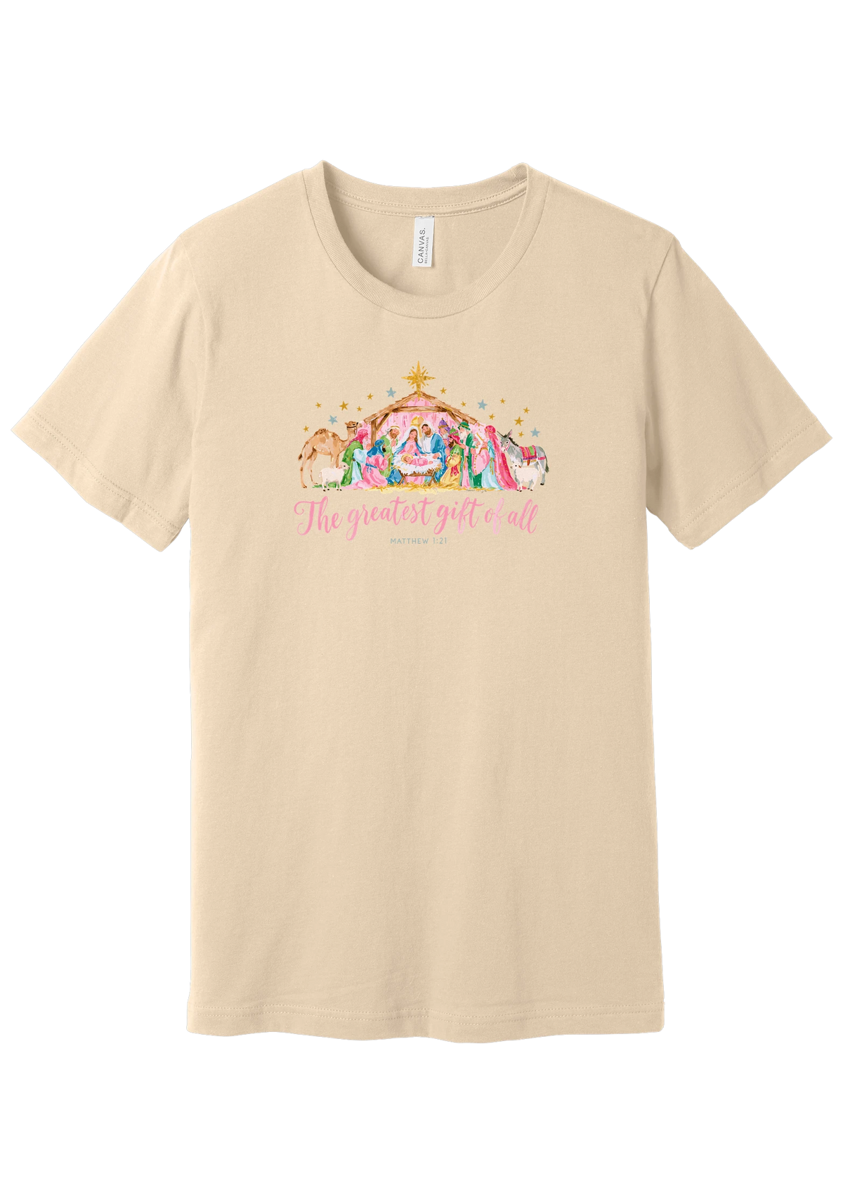 The Greatest Gift of All tee in Soft Cream, featuring a soft watercolor nativity scene beneath the star with Matthew 1:21