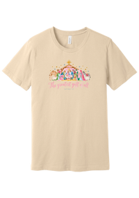 The Greatest Gift of All tee in Soft Cream, featuring a soft watercolor nativity scene beneath the star with Matthew 1:21