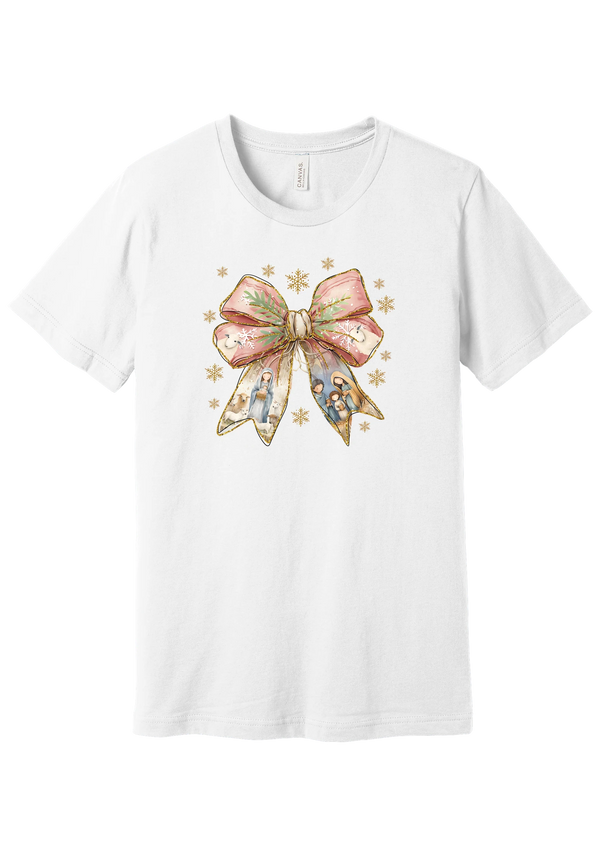 Nativity Bow tee in White, featuring a blush satin bow with painted nativity scenes in its ribbons and gold snowflakes
