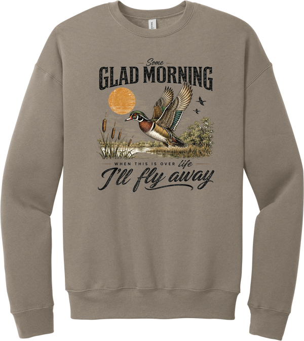 Some Glad Morning crewneck sweatshirt in Tan, featuring a hand-painted wood duck taking flight over a marsh at sunrise with Some glad morning when this life is over I'll fly away